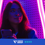 Girl with phone in pink neon light room