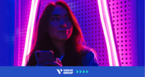 Girl with phone in pink neon light room