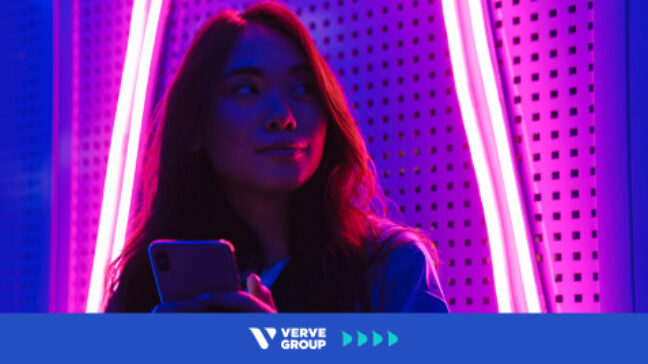 Girl with phone in pink neon light room